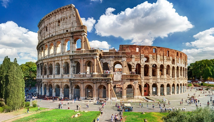 Couple standing in front of the Colosseum, Rome, Italy.