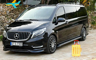 Black luxury van for VIP airport transfer in Antalya, parked on a stone driveway.
