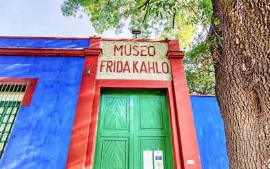 Frida Kahlo Museum entrance with blue walls and green door in Mexico City.