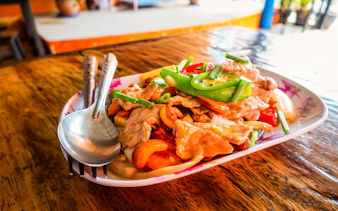 Stir-fried pork with vegetables served on a plate during Mae Ping River Cruise lunch.