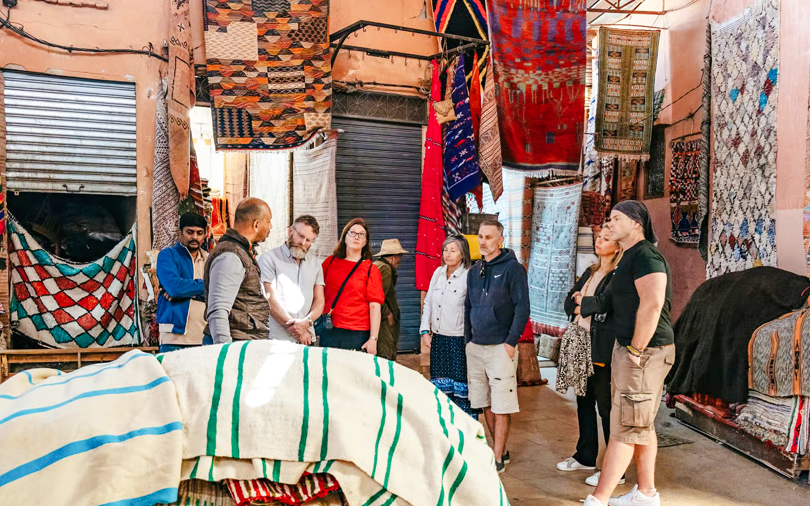 Group exploring vibrant textile market in Marrakech souks.