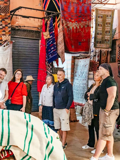 Group exploring vibrant textile market in Marrakech souks.
