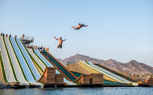 Participants jumping from slides at Hatta Wadi Hub adventure park, UAE.