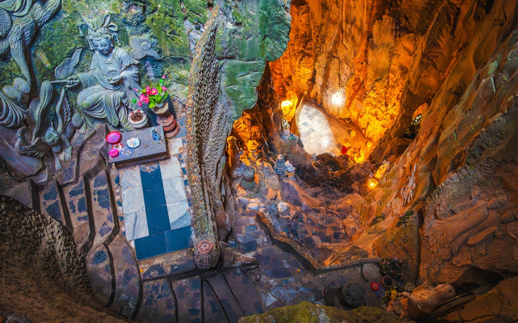 Interior view of Am Phu Cave with stone carvings and altar, Marble Mountains, Đà Nẵng, Vietnam.