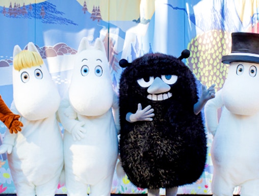 Characters from Moomin Valley Park on stage in front of a colorful backdrop.