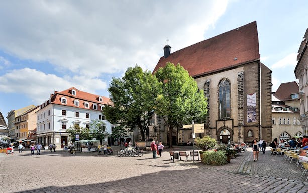 Kreuzberg square with historic buildings and people enjoying outdoor cafes.