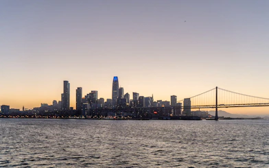 City skyline and bridge at sunset during California cruise.