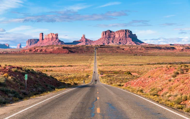 Open road of Route 163 leading to Monument Valley in the background.