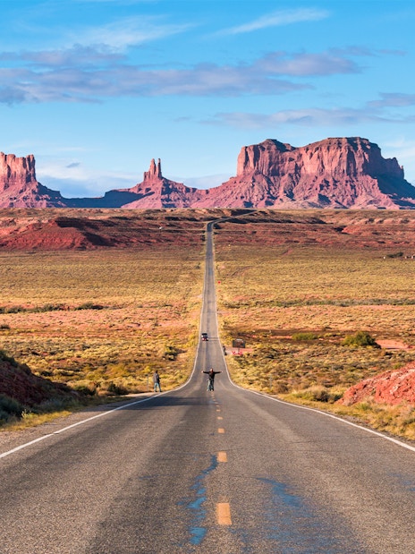 Open road of Route 163 leading to Monument Valley in the background.