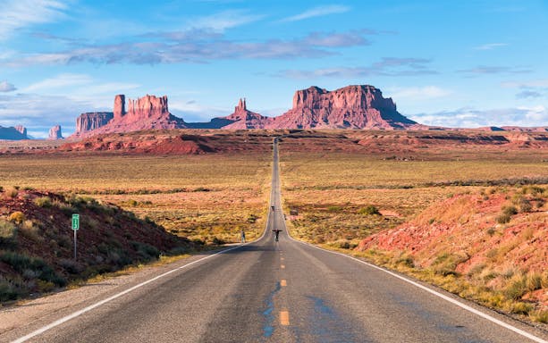 Open road of Route 163 leading to Monument Valley in the background.