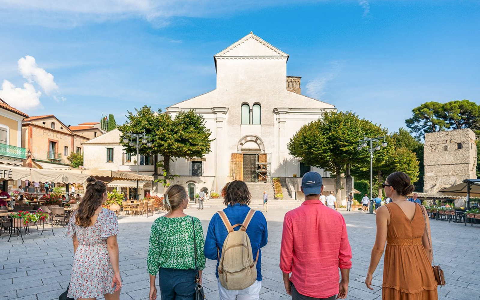 Tourists walking towards a historic church in Ravello, Italy.