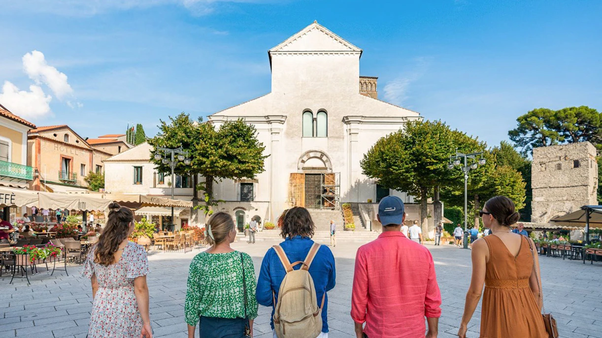 Tourists walking towards a historic church in Ravello, Italy.