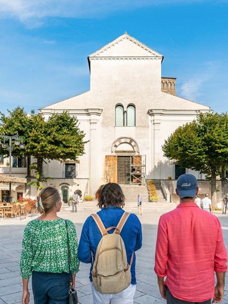 Tourists walking towards a historic church in Ravello, Italy.