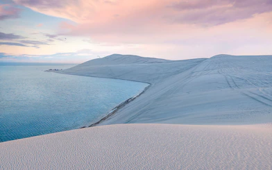 Sunrise over dunes and inland sea in Sea Line Desert near Doha, Qatar.