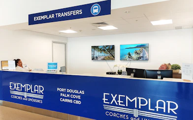Exemplar Transfers desk at Cairns Airport for shared transfer services to Port Douglas and Palm Cove.