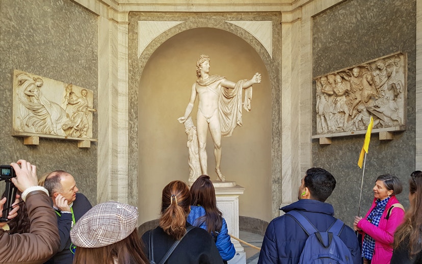 Tourists with guide near Statue of Apollo Belvedere, Vatican Museum.