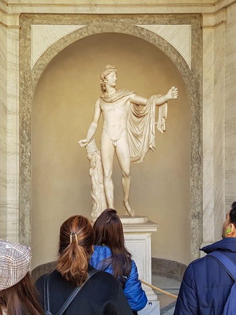 Tourists with guide near Statue of Apollo Belvedere, Vatican Museum.