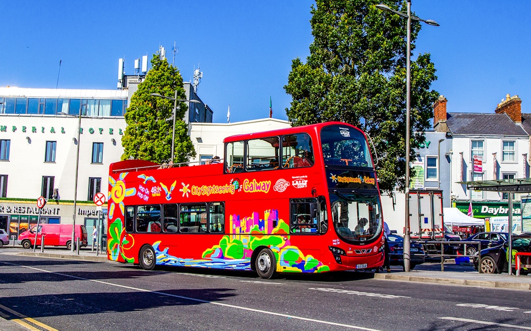 Red double-decker bus on Galway Hop-On-Hop-Off Tour near Imperial Hotel.