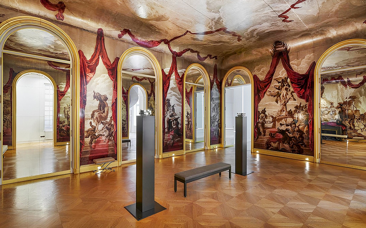 Carnavalet Museum exhibition room with ornate mirrors and historical murals.