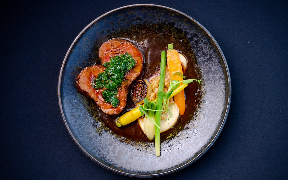 Dinner plate with beef, carrots, and greens at Altitude dining, Melbourne Skydeck.