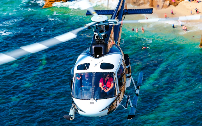 Helicopter flying over a coastal beach during a shared panoramic tour.