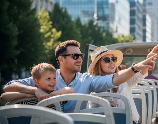 Touristen genießen die Aussicht auf die Stadt bei einer Hop-on Hop-off Bustour.