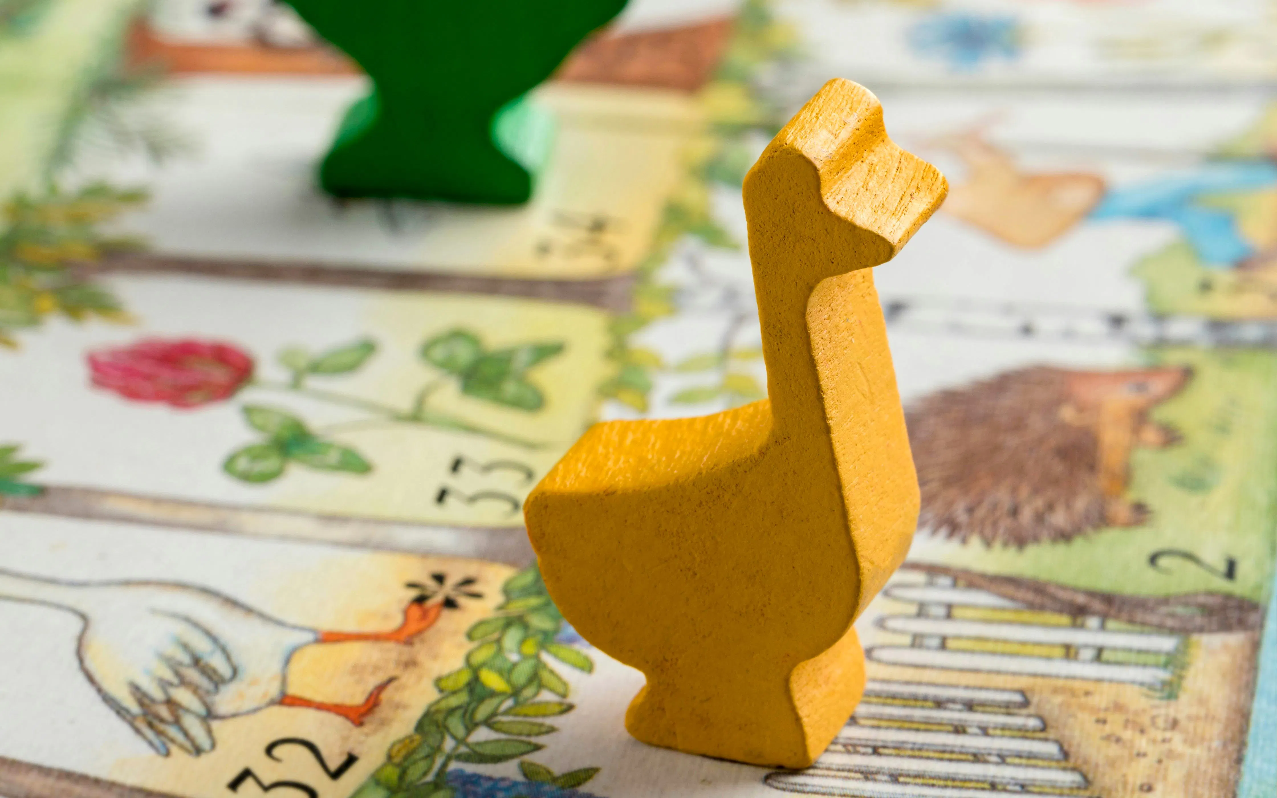 Yellow goose piece on Game of the Goose board close-up.