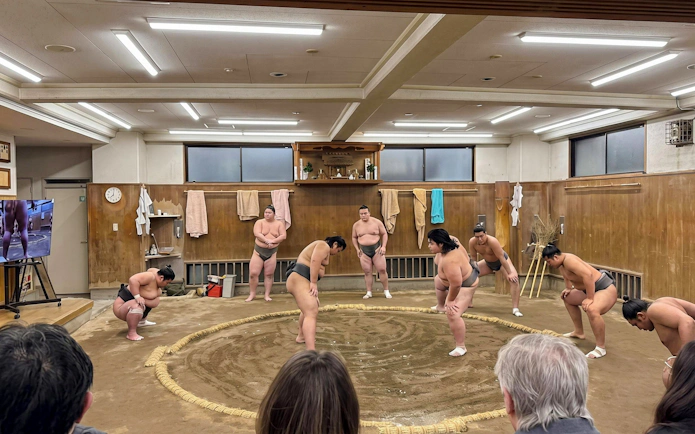 Sumo wrestlers warming up in a Tokyo dojo for Private Grand Sumo Tournament.