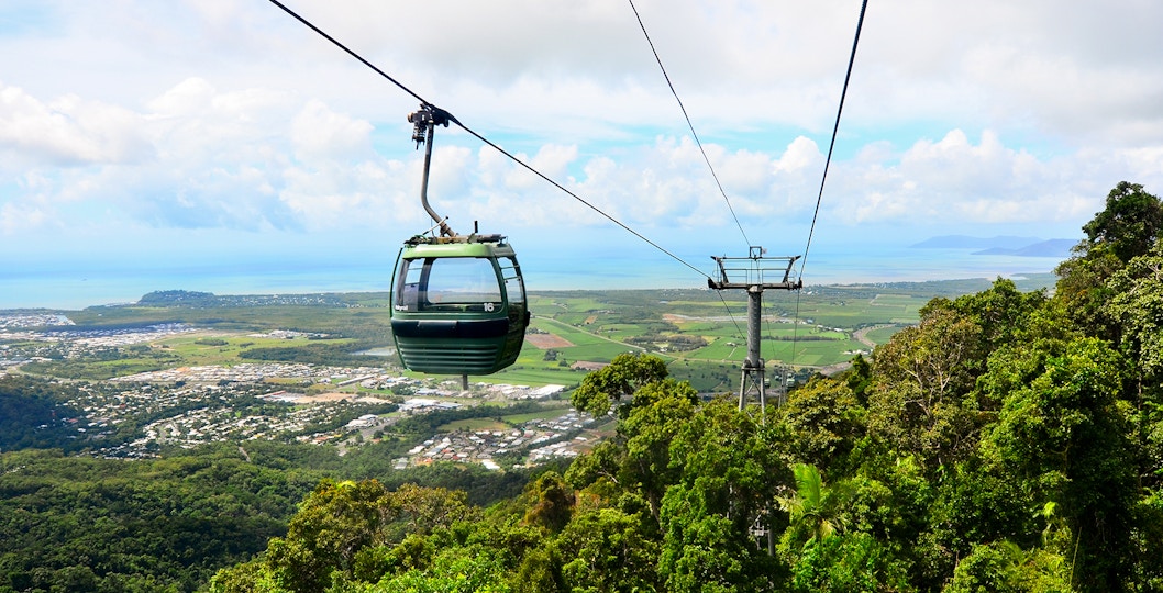 Cable car over lush landscape with ocean view in Australia.