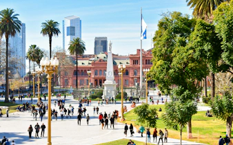 People walking in Plaza de Mayo with Casa Rosada in Buenos Aires, Argentina.