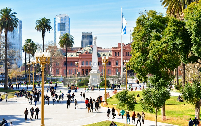 People walking in Plaza de Mayo with Casa Rosada in Buenos Aires, Argentina.