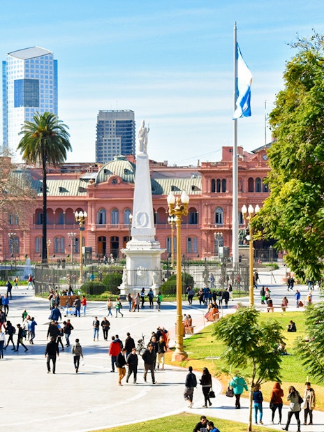 People walking in Plaza de Mayo with Casa Rosada in Buenos Aires, Argentina.