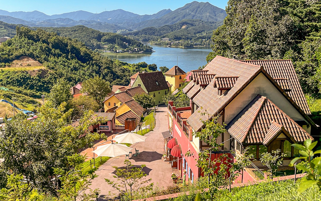 Colorful French-style village buildings in Petite France near Gapyeong, South Korea, overlooking a lake.