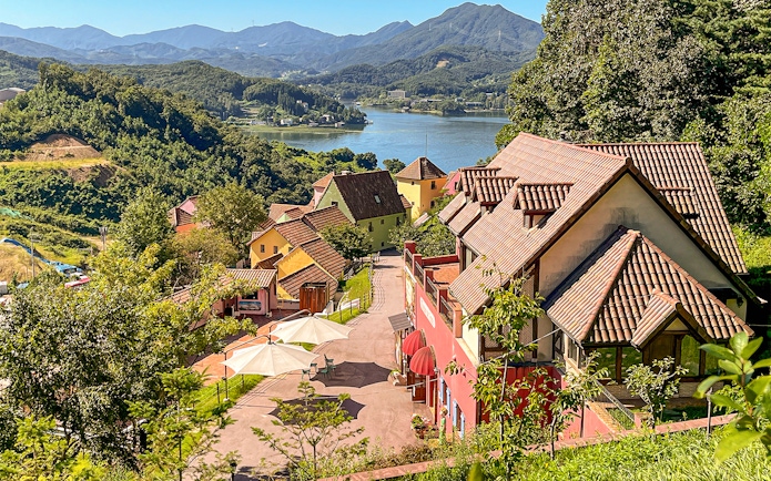 Colorful French-style village buildings in Petite France near Gapyeong, South Korea, overlooking a lake.