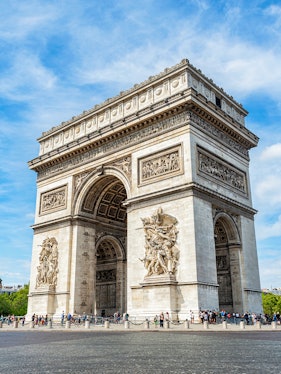 Arc de Triomphe in Paris with detailed sculptures and tourists nearby.