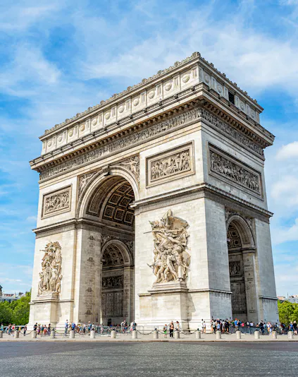 Arc de Triomphe in Paris with detailed sculptures and tourists nearby.