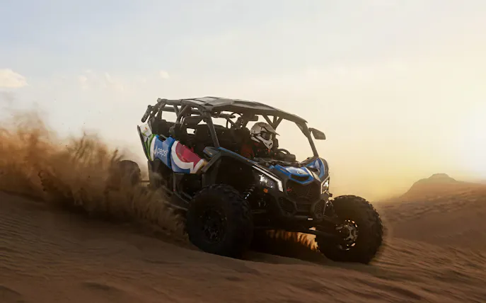 4-seater desert buggy driving through sand dunes at sunset.