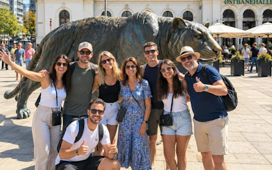 Group posing by the tiger statue at Oslo Central Station during a walking tour.
