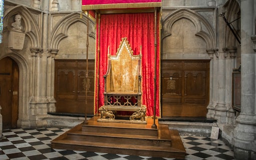 Coronation Chair at Westminster Abbey with red drapery backdrop.