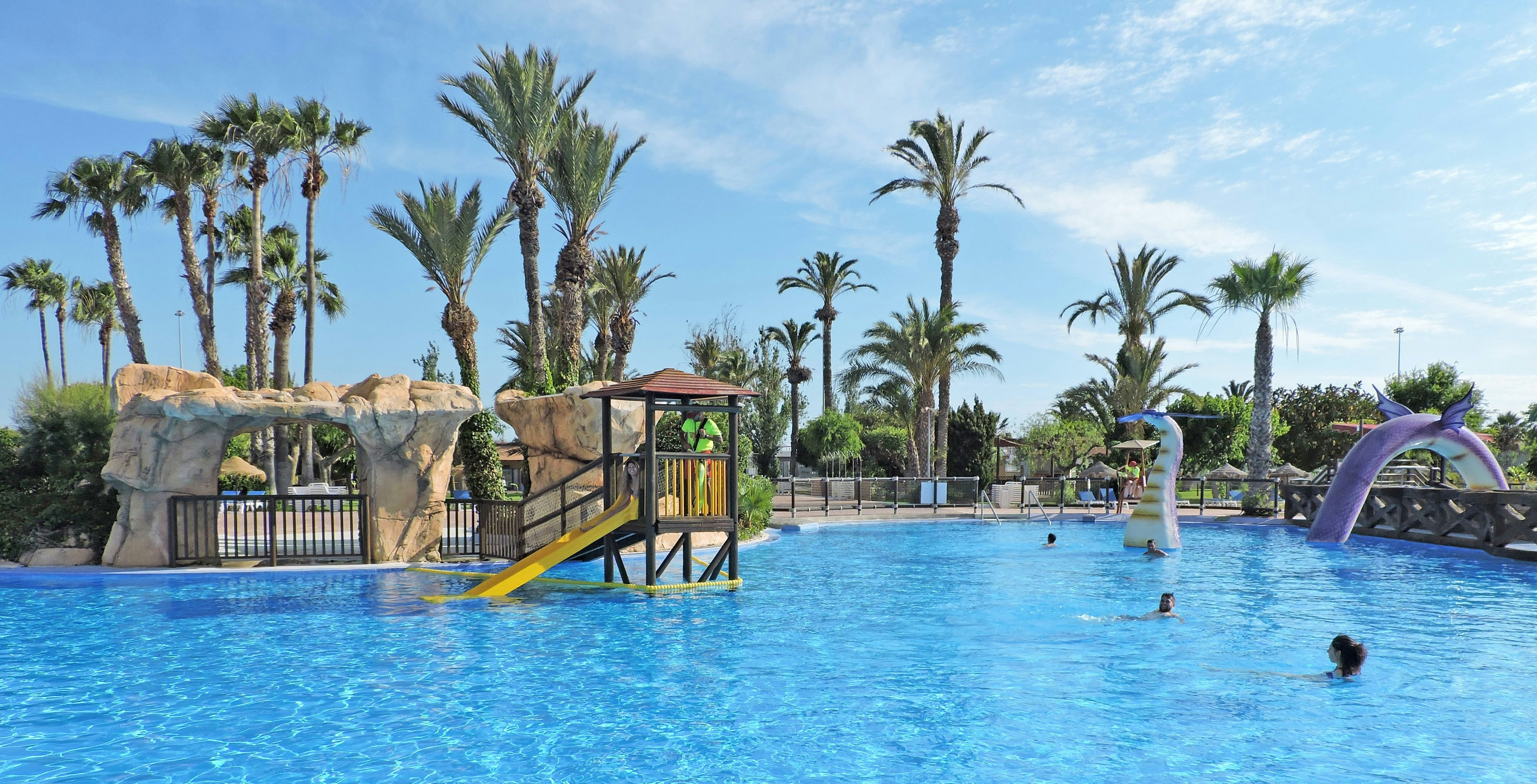 Water park pool with slides and palm trees at Aqualand Torremolinos.