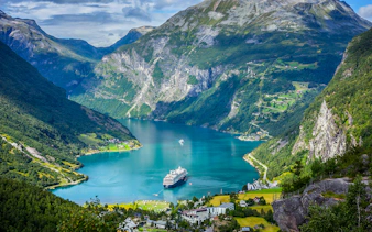 Cruise ship in Geirangerfjord surrounded by mountains on Ålesund-Geiranger-Ålesund tour.