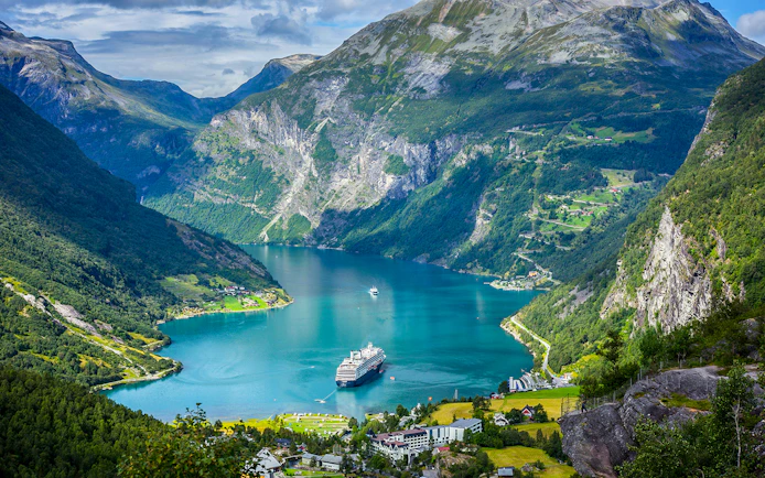Cruise ship in Geirangerfjord surrounded by mountains on Ålesund-Geiranger-Ålesund tour.