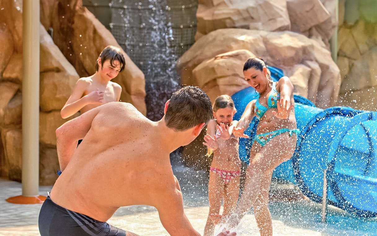 Family playing in water at Canyon Adventure zone, Aqualibi Belgium.