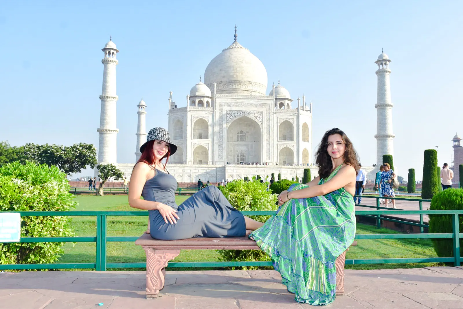 Visitors sitting on a bench with the Taj Mahal in the background, Agra.