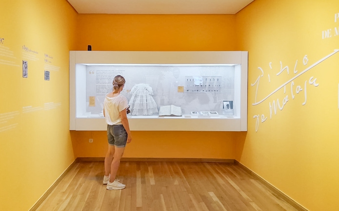 Visitor observing exhibit at Picasso's Birthplace Museum in Málaga.