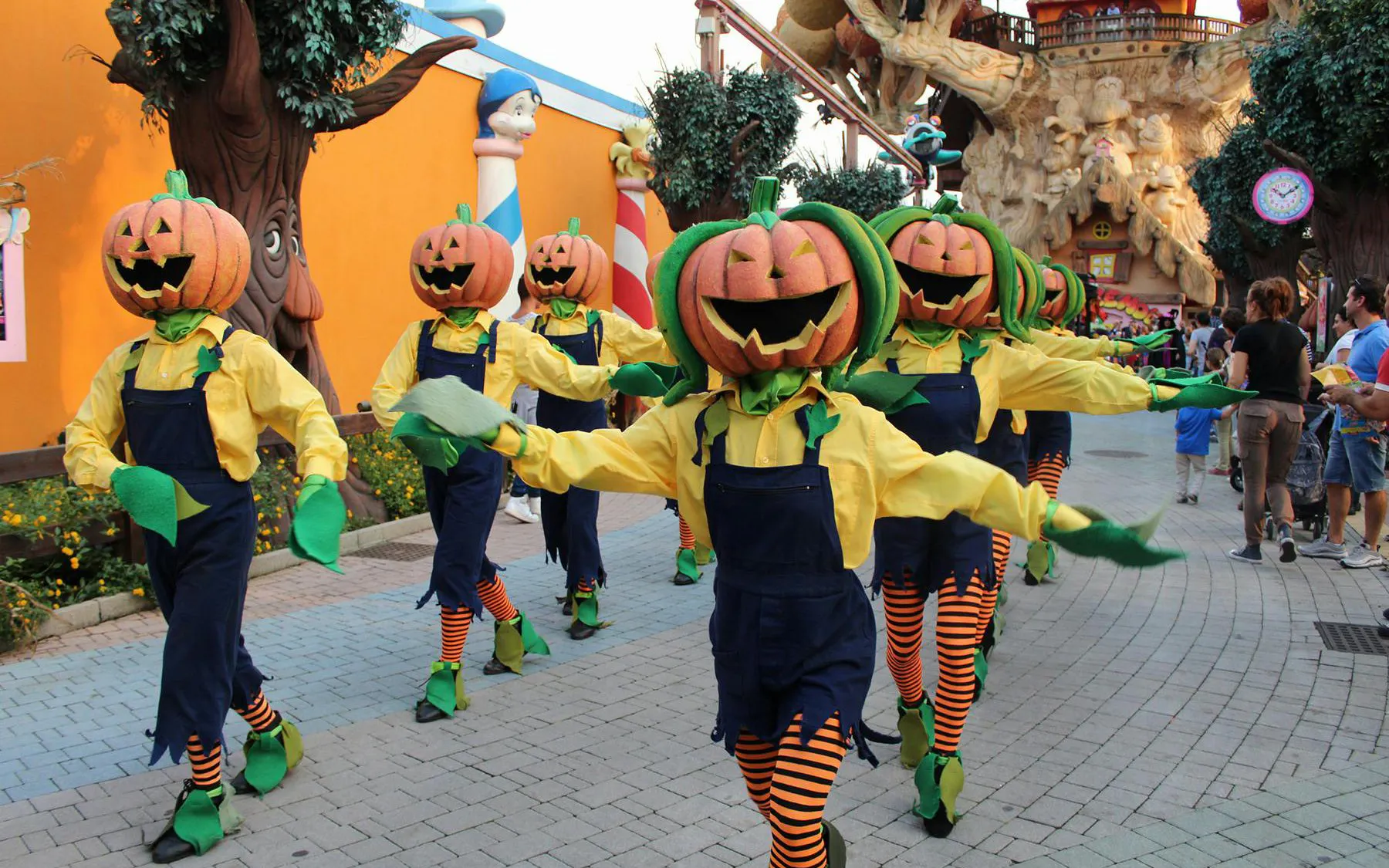 Pumpkin-headed performers in costume parade at Gardaland Halloween event.