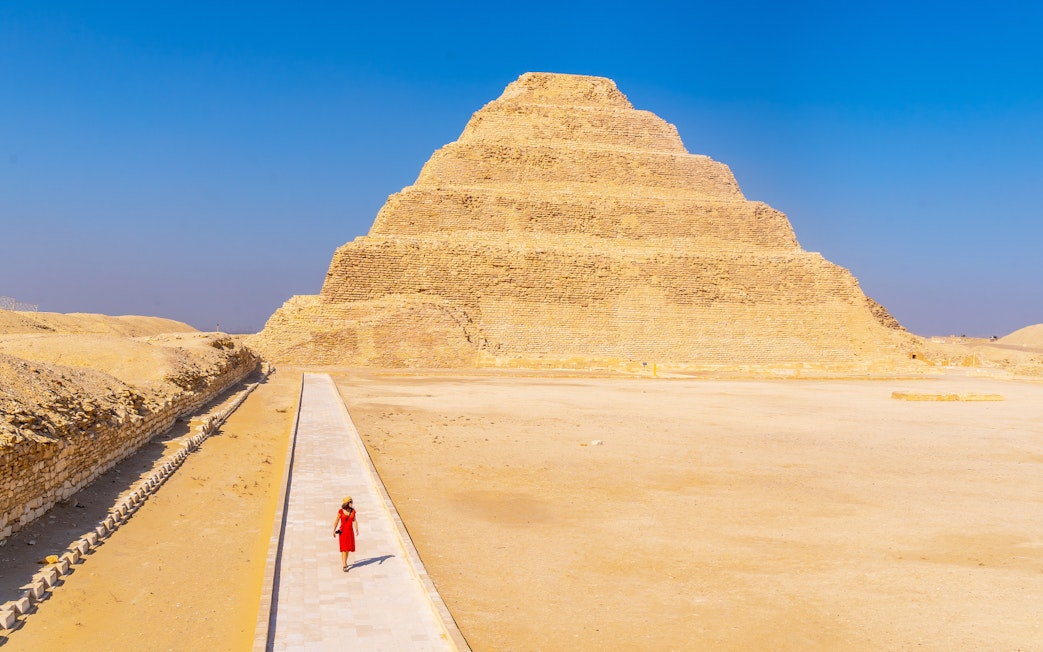 Person walking towards the Pyramid of Djoser in Giza, Egypt.