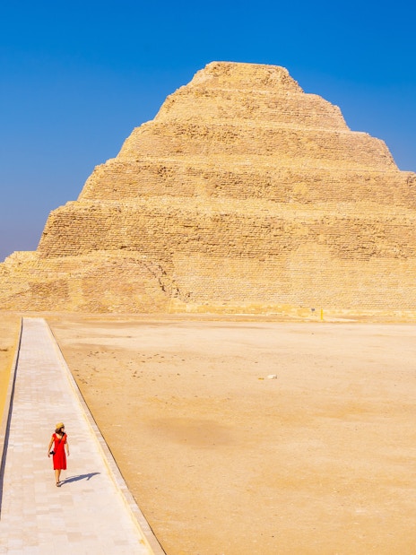 Person walking towards the Pyramid of Djoser in Giza, Egypt.
