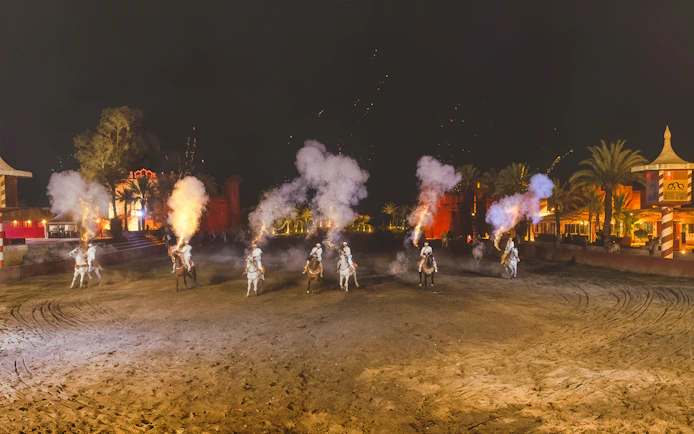 Riders on horses with smoke effects at Chez Ali Dinner & Fantasia Show, Morocco.