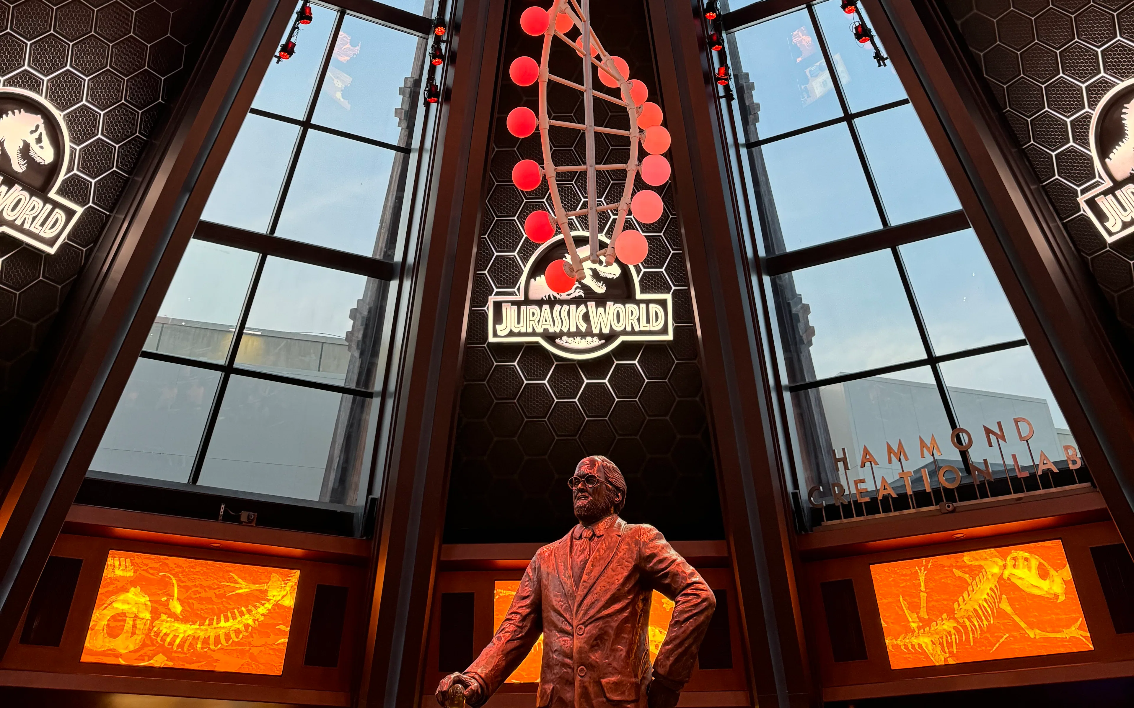 Interior of Jurassic World Adventure at Universal Studios Beijing featuring a statue and dinosaur displays.